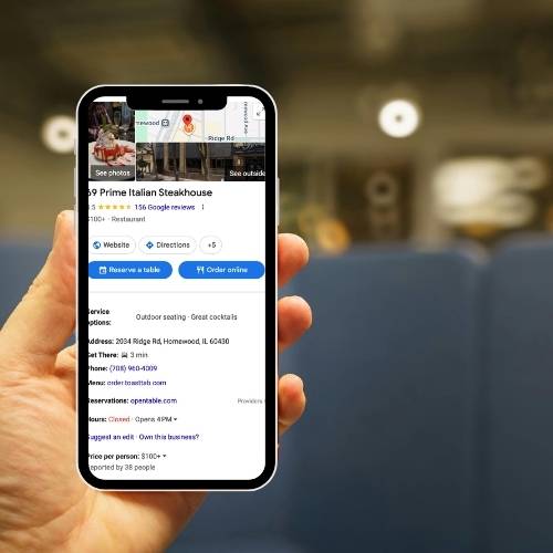 Google Business Optimization holding phone to show a google business page